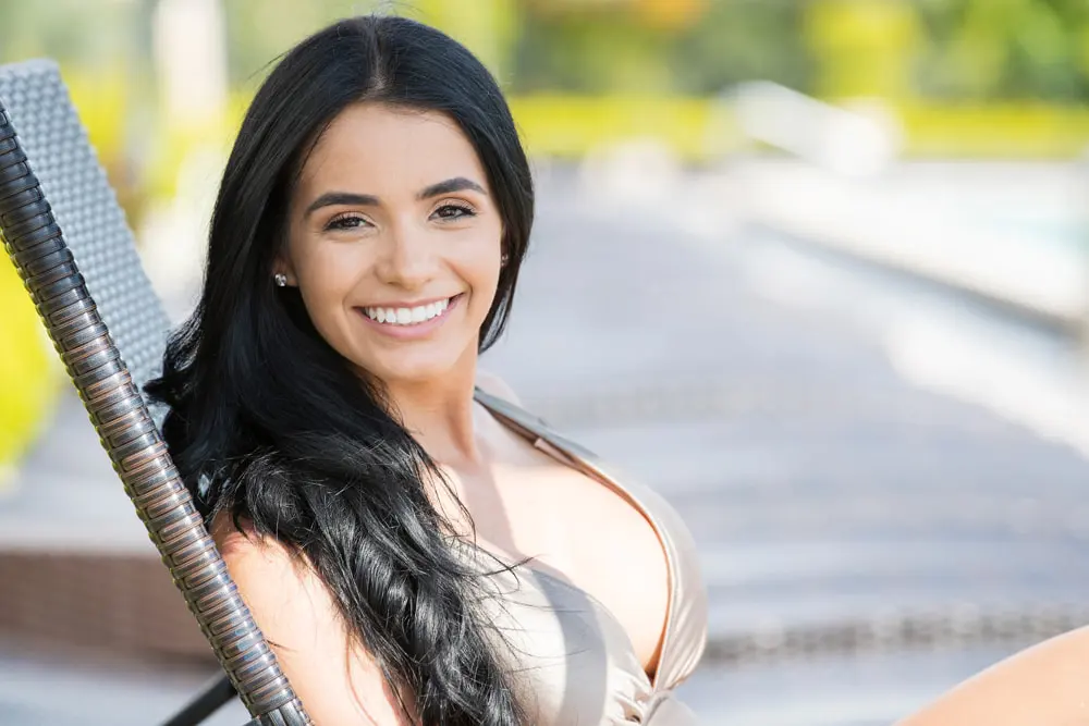 mulheres latinas tomando bronzeado na beira da piscina